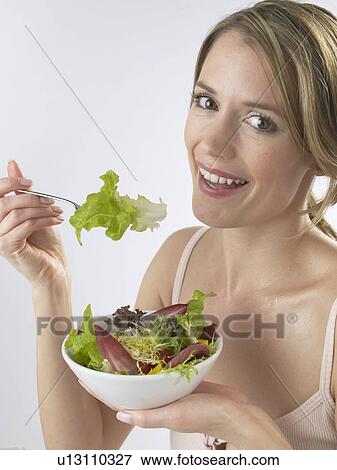 Stock Photo - Woman is eating salad. Fotosearch