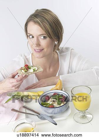 Woman is having breakfast with crispbread and cereals View Large Photo Image Picture - Woman is having breakfast with crispbread and cereals. Fotosearch