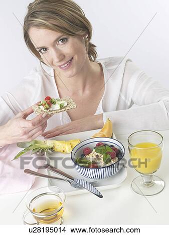Woman is having breakfast with crispbread and cereals View Large Photo Image Picture - Woman is having breakfast with crispbread and cereals. Fotosearch