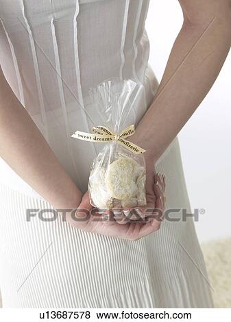 Woman is hiding biscuits behind her back View Large Photo Image Stock Photo - Woman is hiding biscuits behind her back. Fotosearch