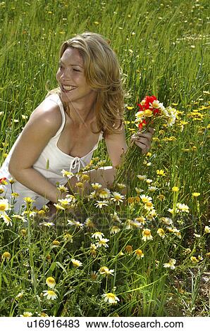 Woman is picking summer flowers in the meadow View Large Photo Image Stock Image - Woman is picking summer flowers in the meadow. Fotosearch