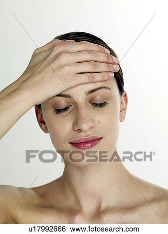 Stock Photograph - Woman is putting hands on her face. Fotosearch