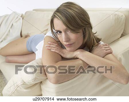 Picture - Woman lounging on a sofa. Fotosearch