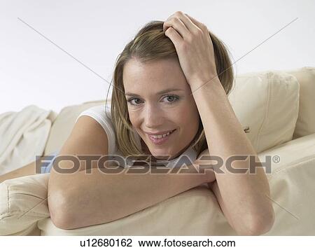Woman lounging on a sofa View Large Photo Image Stock Image - Woman lounging on a sofa. Fotosearch