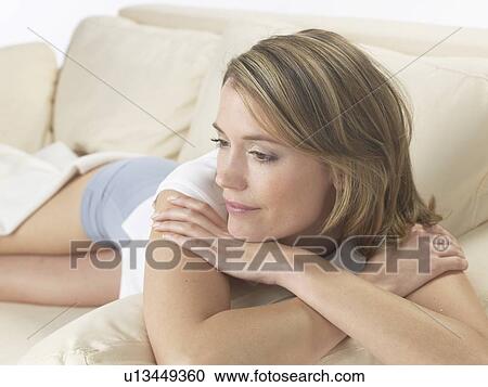 Woman lounging on a sofa View Large Photo Image Stock Image - Woman lounging on a sofa. Fotosearch