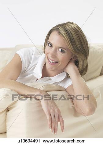Stock Image - Woman lounging on a sofa. Fotosearch