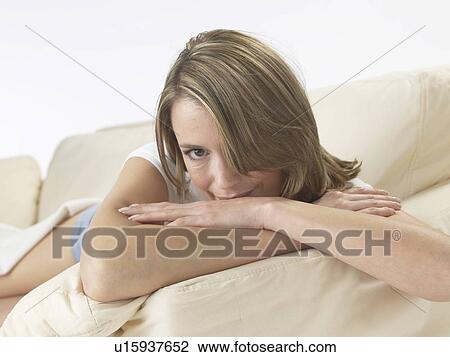 Stock Image - Woman lounging on a sofa. Fotosearch