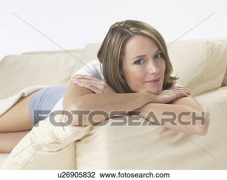 Stock Image - Woman lounging on a sofa. Fotosearch