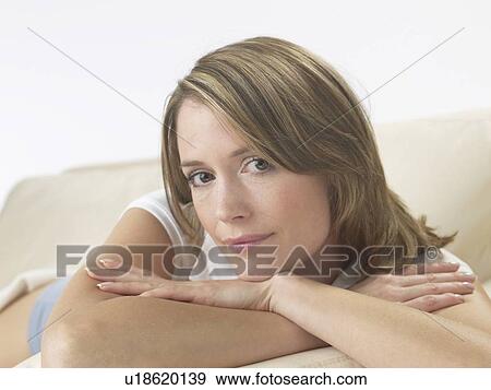 Stock Photo - Woman lounging on a sofa. Fotosearch