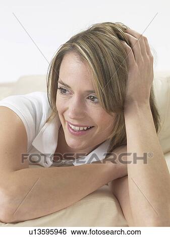 Stock Photograph - Woman lounging on a sofa. Fotosearch