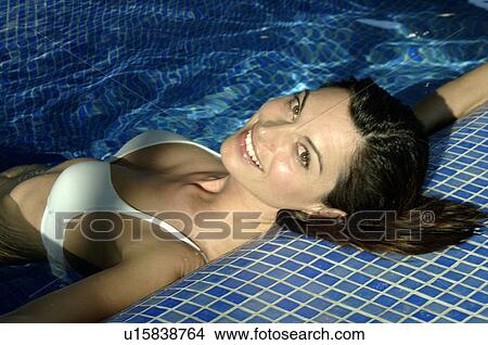 Picture - Woman lying in a swimming pool. Fotosearch