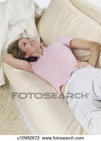 Woman lying on a sofa View Large Photo Image Stock Image - Woman lying on a sofa. Fotosearch