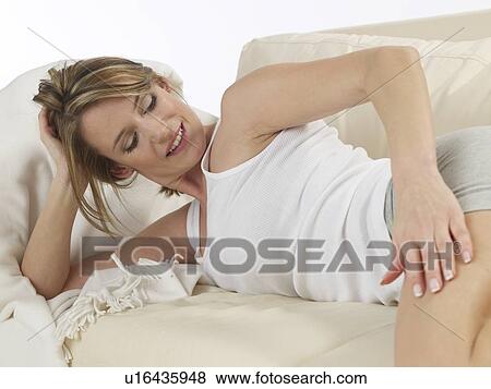 Woman lying on a sofa View Large Photo Image Stock Photo - Woman lying on a sofa. Fotosearch