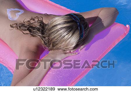 Woman on a airmattress with a sun lotion heart on her back View Large Photo Image Stock Photo - Woman on a airmattress with a sun lotion heart on her back. Fotosearch