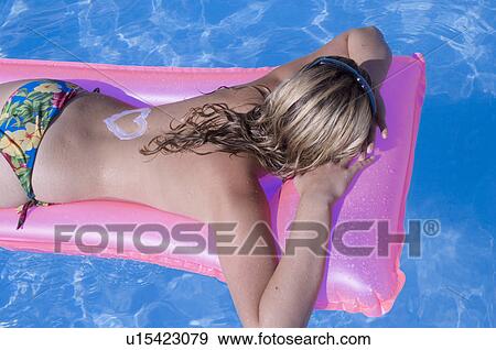 Woman on a airmattress with a sun lotion heart on her back View Large Photo Image Stock Photo - Woman on a airmattress with a sun lotion heart on her back. Fotosearch