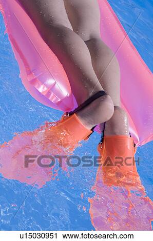Stock Image - Woman on a airmattress with flippers. Fotosearch