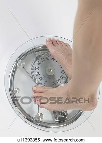 Stock Photography - Woman on a bathroom scale, feet. Fotosearch