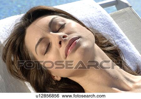 Woman on sunlounger at the swimming pool View Large Photo Image Stock Photograph - Woman on sunlounger at the swimming pool. Fotosearch