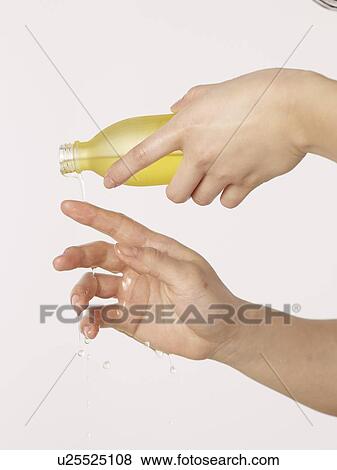 Woman pouring oil over her hands View Large Photo Image Stock Photo - Woman pouring oil over her hands. Fotosearch