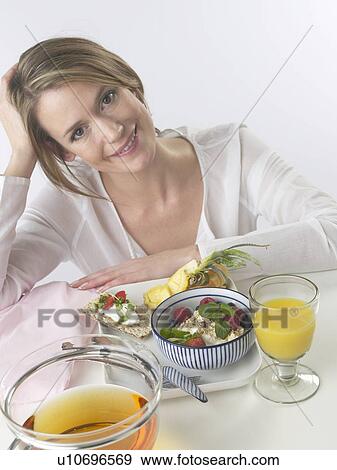 Stock Photo - Woman sitting at a breakfast table. Fotosearch
