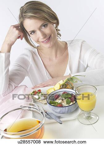Stock Photo - Woman sitting at a breakfast table. Fotosearch