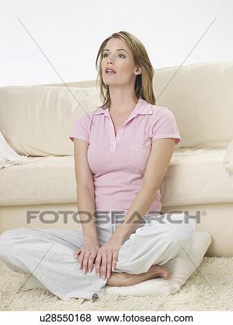 Stock Photo - Woman sitting in front of a sofa. Fotosearch