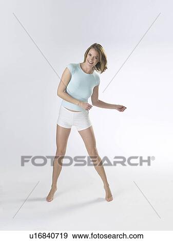 Stock Photo - Woman wearing white shorts and a t-shirt poses. Fotosearch