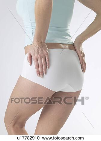 Stock Image - Woman wearing white underwear, detail of waist and backside. Fotosearch