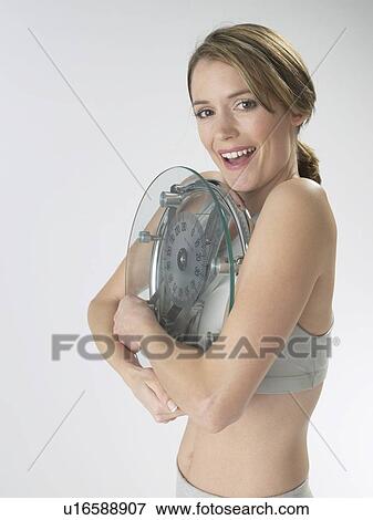 Woman with a bathroom scale View Large Photo Image Stock Photo - Woman with a bathroom scale. Fotosearch