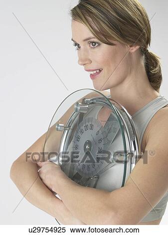Woman with a bathroom scale View Large Photo Image Stock Photography - Woman with a bathroom scale. Fotosearch