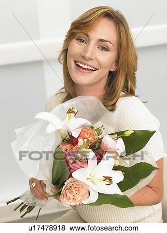 Woman with a bouquet sitting on her desk View Large Photo Image Stock Photo - Woman with a bouquet sitting on her desk. Fotosearch