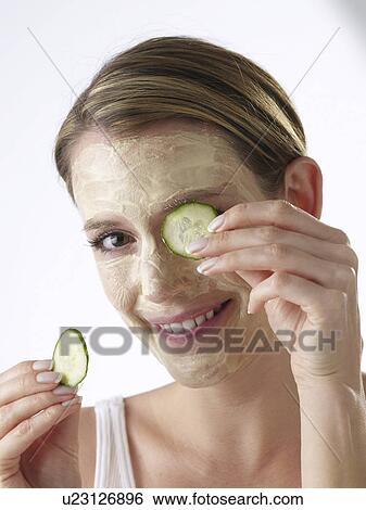 Stock Photograph - Woman with a cucumber mask. Fotosearch