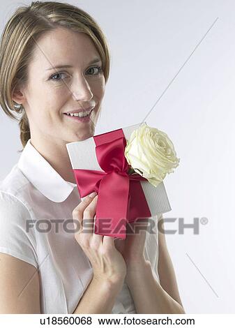 Woman with a gift and white rose blossom View Large Photo Image Stock Photo - Woman with a gift and white rose blossom. Fotosearch
