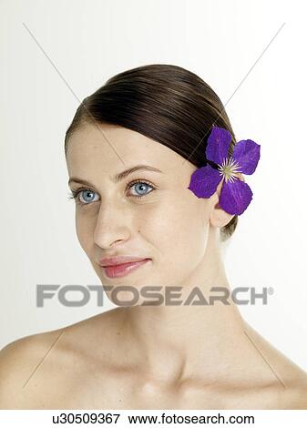 Woman with a lilac blossom in her hair View Large Photo Image Stock Photo - Woman with a lilac blossom in her hair. Fotosearch