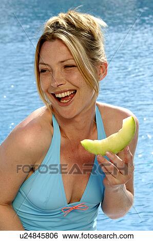 Woman with a piece of sweet melon View Large Photo Image Stock Photograph - Woman with a piece of sweet melon. Fotosearch