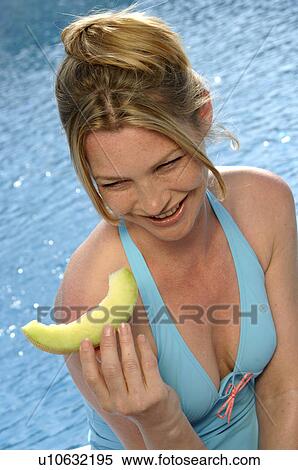 Stock Photography - Woman with a piece of sweet melon. Fotosearch