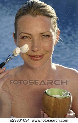 Picture - Woman with facial mask and brush. Fotosearch
