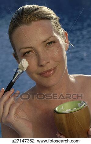 Stock Image - Woman with facial mask and brush. Fotosearch