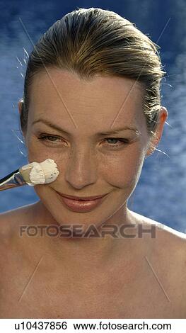 Stock Photograph - Woman with facial mask and brush. Fotosearch