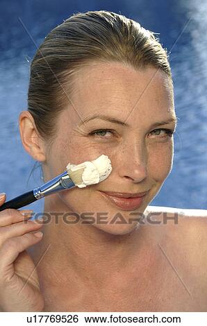 Stock Photograph - Woman with facial mask and brush. Fotosearch