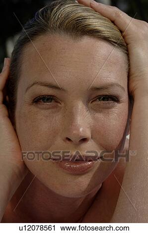 Stock Image - Woman with hands on her face. Fotosearch