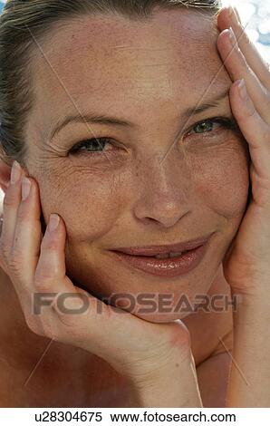 Stock Photography - Woman with hands on her face. Fotosearch