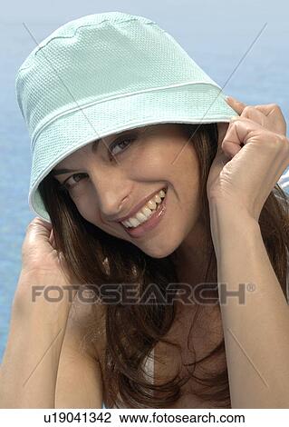 Stock Image - Woman with sun hat at the swimming pool. Fotosearch