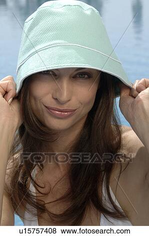 Stock Photo - Woman with sun hat at the swimming pool. Fotosearch