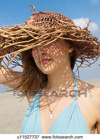 Stock Photo - Woman with sun hat on the beach. Fotosearch