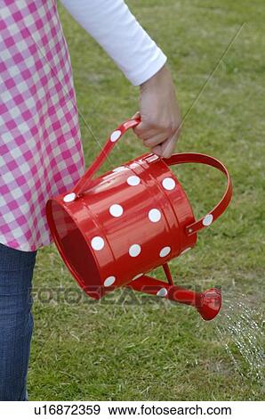 Stock Photo - Woman with watering can in garden. Fotosearch