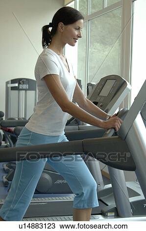 Woman working out on the treadmill View Large Photo Image Stock Image - Woman working out on the treadmill. Fotosearch