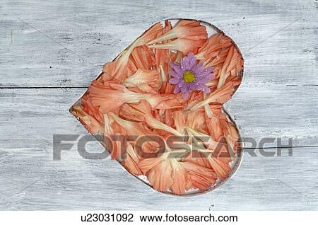 Stock Image - Wooden plank with heart of blossoms. Fotosearch