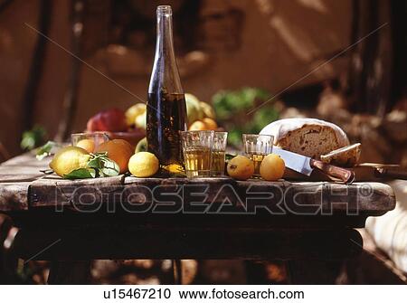 Wooden table with oil, glasses, bread and lemons outdoors View Large Photo Image Stock Image - Wooden table with oil, glasses, bread and lemons outdoors. Fotosearch