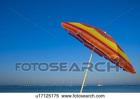 Stock Photography - Yellow and red sunshade on the beach. Fotosearch